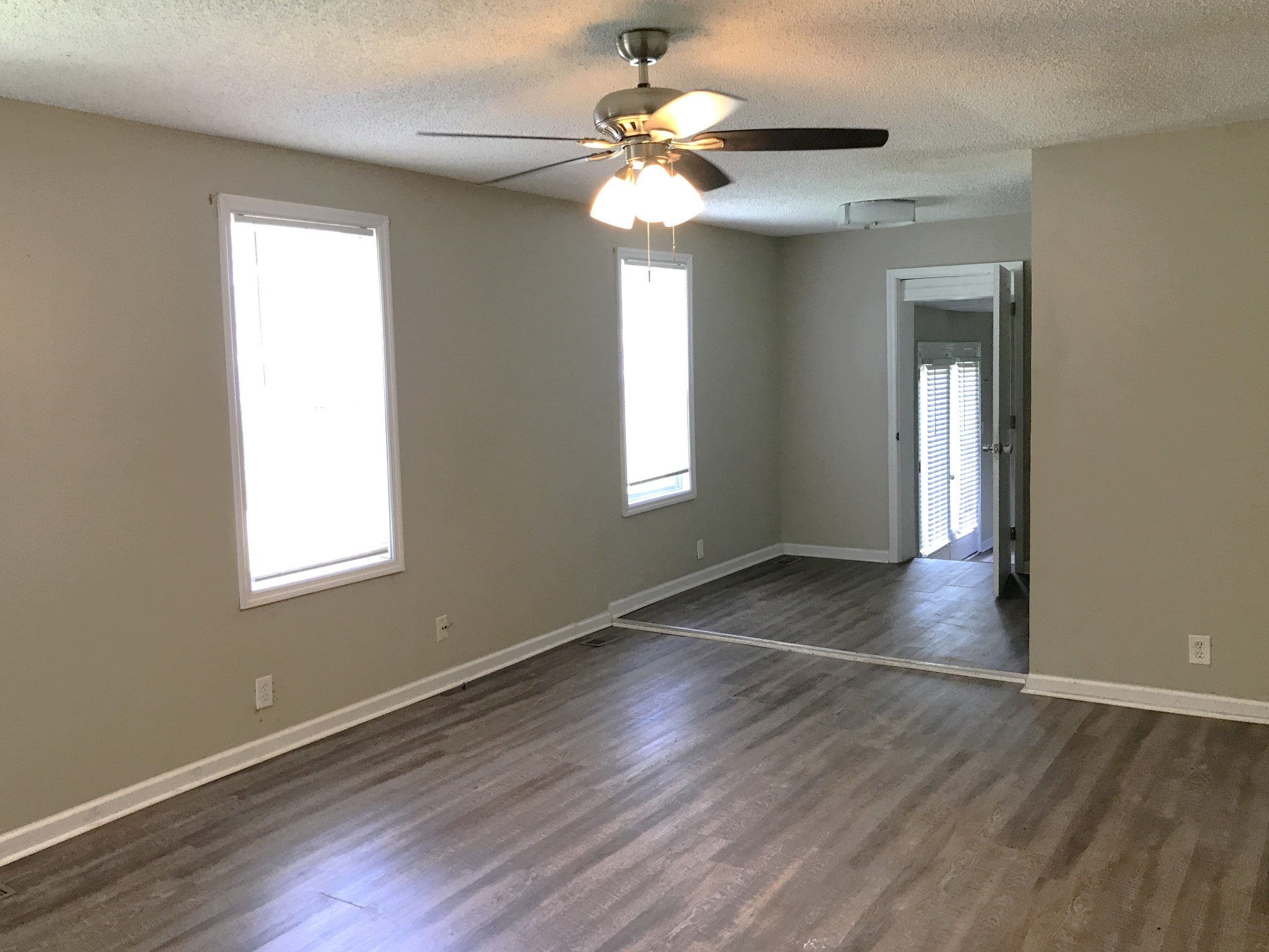6558 Kari Drive Murfreesboro, TN 37129 - Photo 2 of 12 an empty room with wooden floor chandelier fan and windows