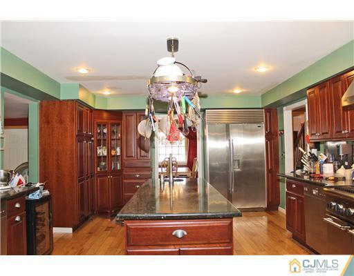 36 Runnymede Road Colonia, NJ 07067 - Photo 4 of 25 a kitchen with stainless steel appliances kitchen island granite countertop a refrigerator