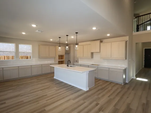a large kitchen with a lot of counter space and wooden floor