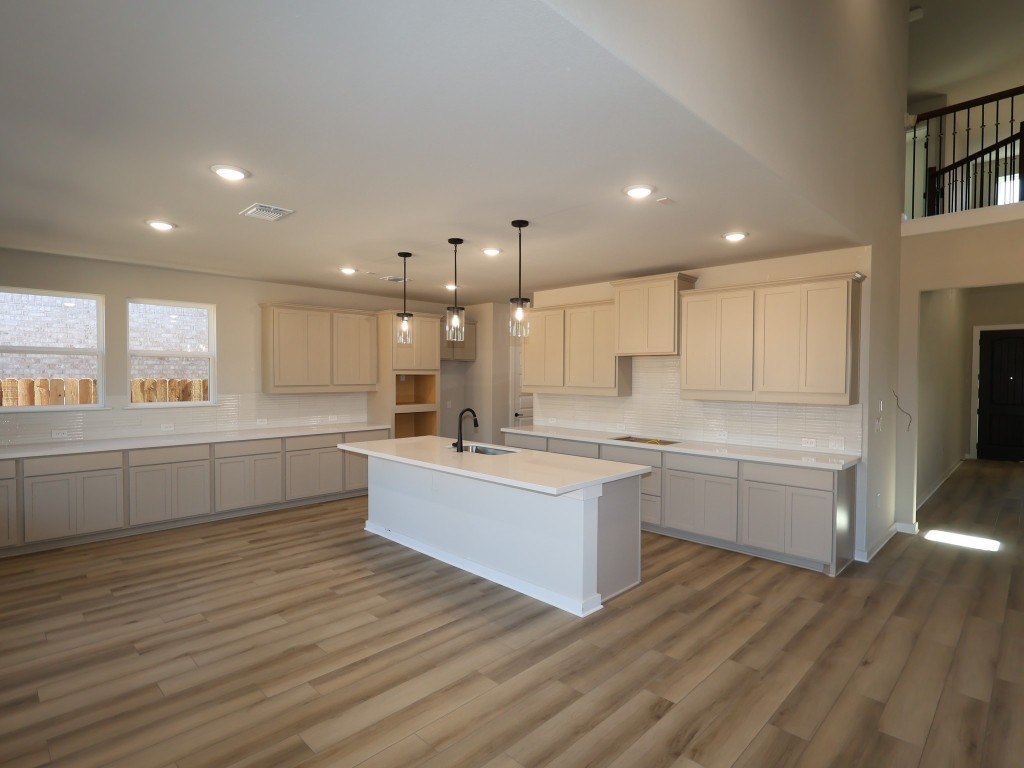 3713 Helena Way Leander, TX 78641 - Photo 2 of 28 a large kitchen with a lot of counter space and wooden floor