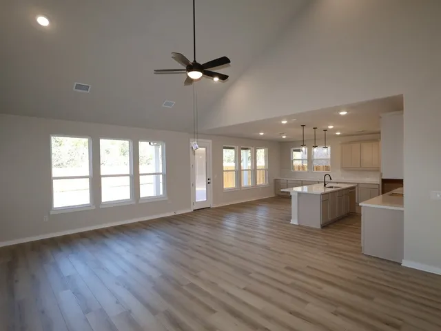 a living room with hard wood floors and a kitchen