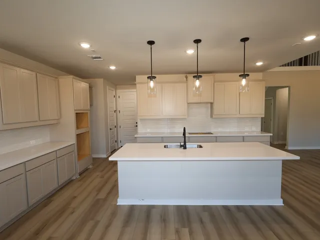 a large kitchen with kitchen island a sink stainless steel appliances and cabinets