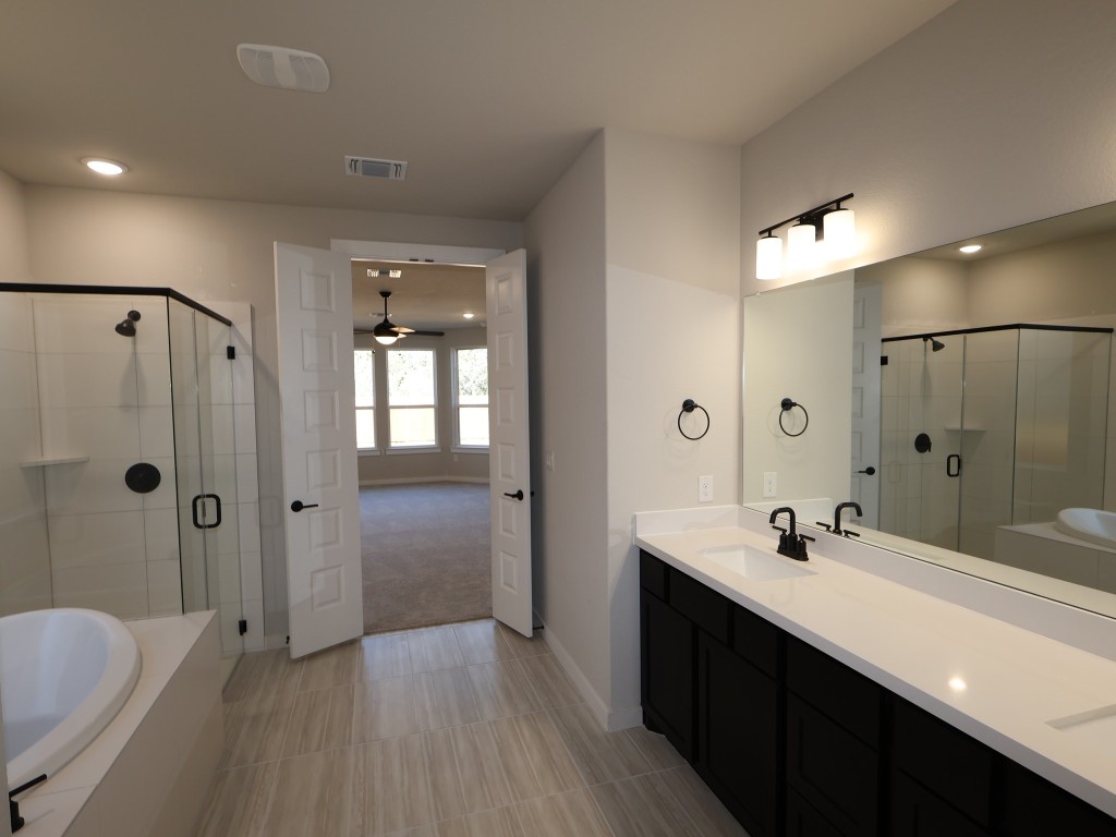 3713 Helena Way Leander, TX 78641 - Photo 10 of 28 a bathroom with a double vanity sink a toilet a shower and a mirror