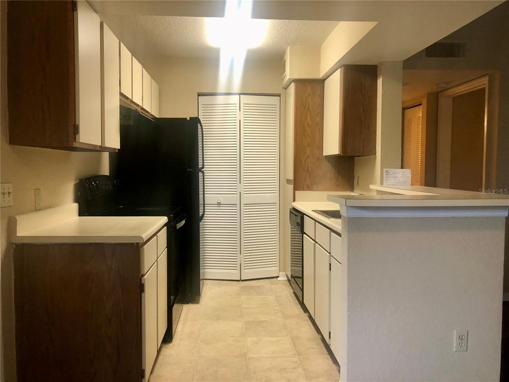 1049 South Hiawassee Road, Unit 3422 Orlando, FL 32835 - Photo 6 of 15 a kitchen with a refrigerator and a stove