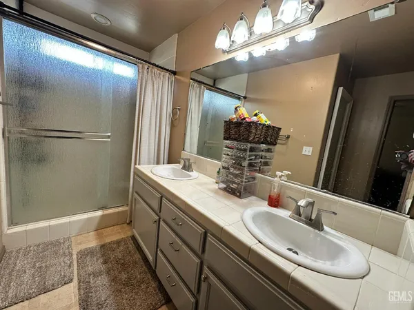 a bathroom with double vanity and a mirror