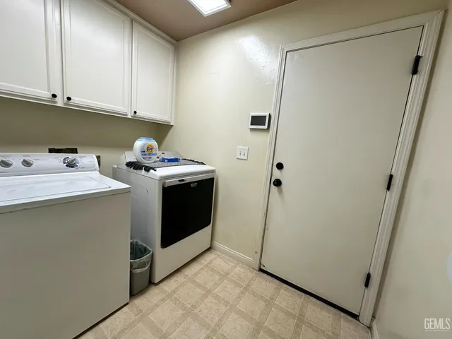 a utility room with cabinets washer and dryer