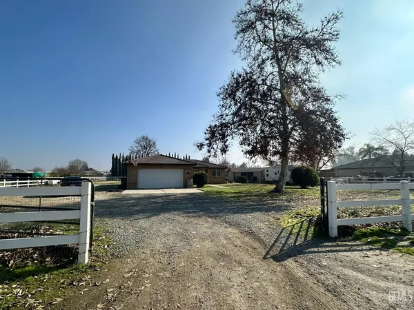 a view of a yard with wooden fence