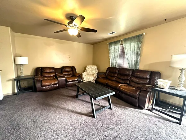 a living room with furniture a air conditioner vent and a window