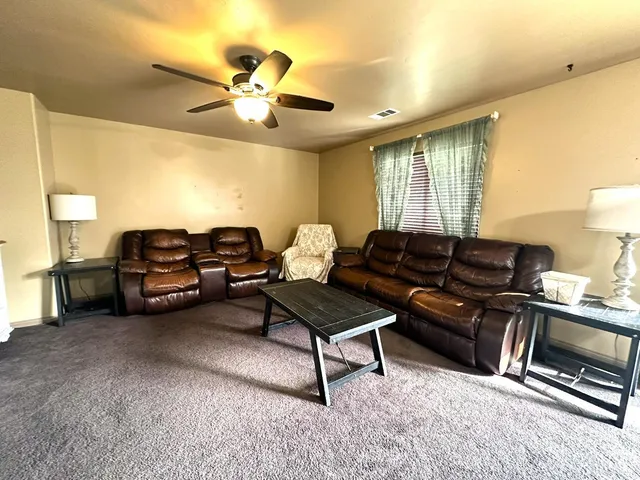 a living room with furniture a air conditioner vent and a window