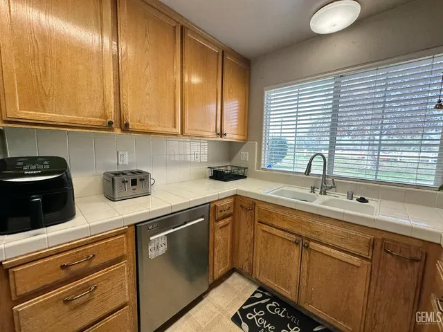 a kitchen with stainless steel appliances granite countertop a sink a stove and cabinets