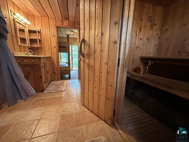 2763 Van Vac Road Ely, MN 55731 - Photo 31 of 37 Wood-paneled bathroom featuring a built-in vanity with integrated sink, open shelving, and tile flooring