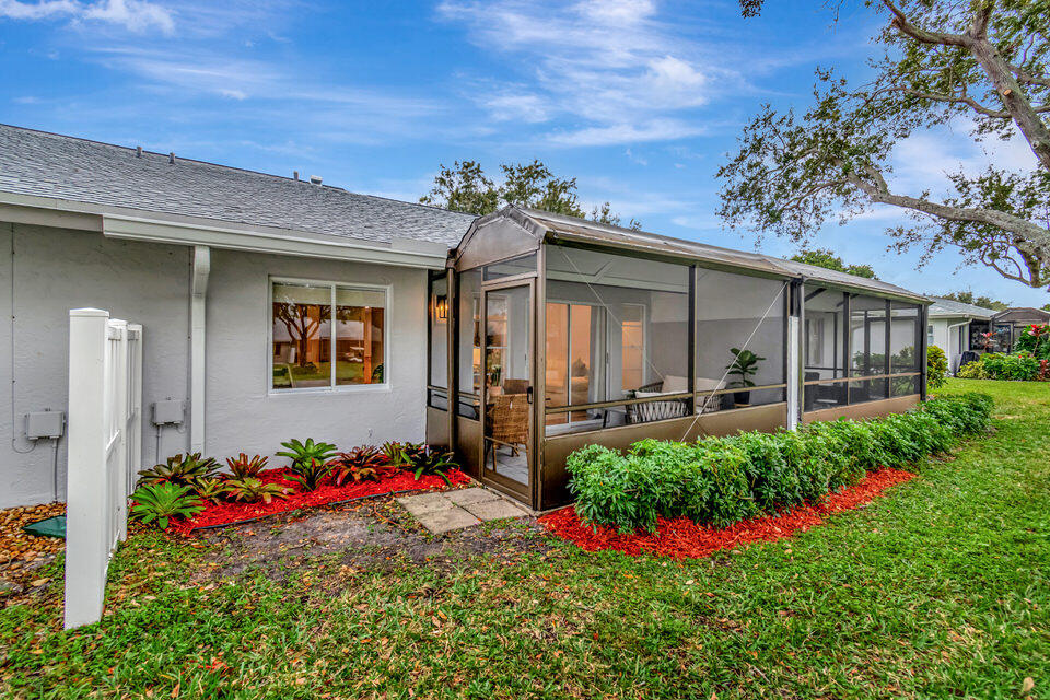8903 Windtree Street Boca Raton, FL 33496 - Photo 15 of 19 a flower garden is sitting in front of a house