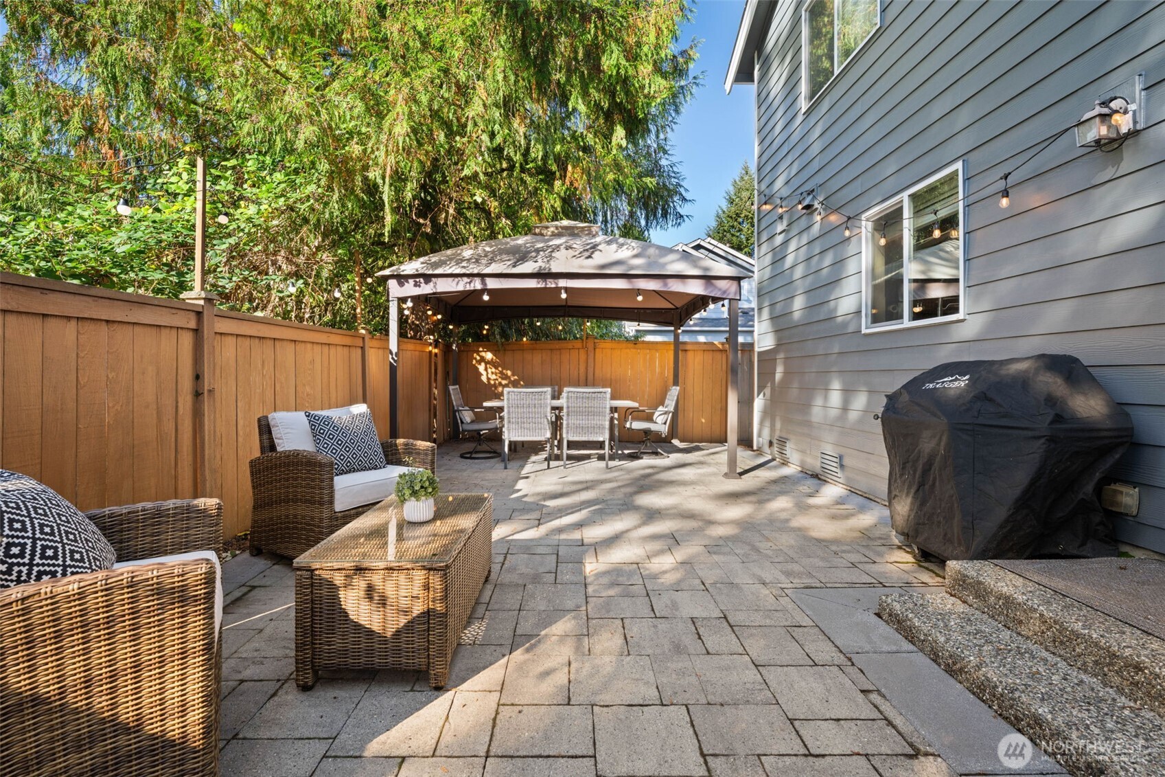 19312 1st Avenue West, Unit 4 Bothell, WA 98012 - Photo 16 of 32 a view of a patio with table and chairs with wooden fence and plants