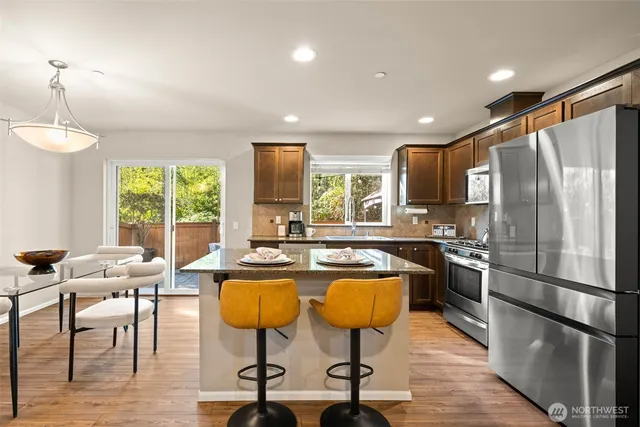 a kitchen with stainless steel appliances granite countertop counter space a refrigerator and furniture
