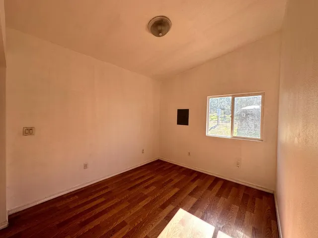 a view of a room with wooden floor and window