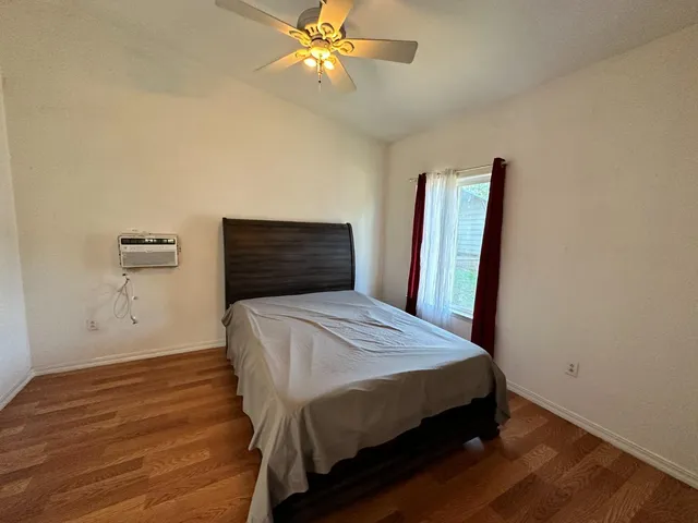 a bedroom with a bed and a ceiling fan