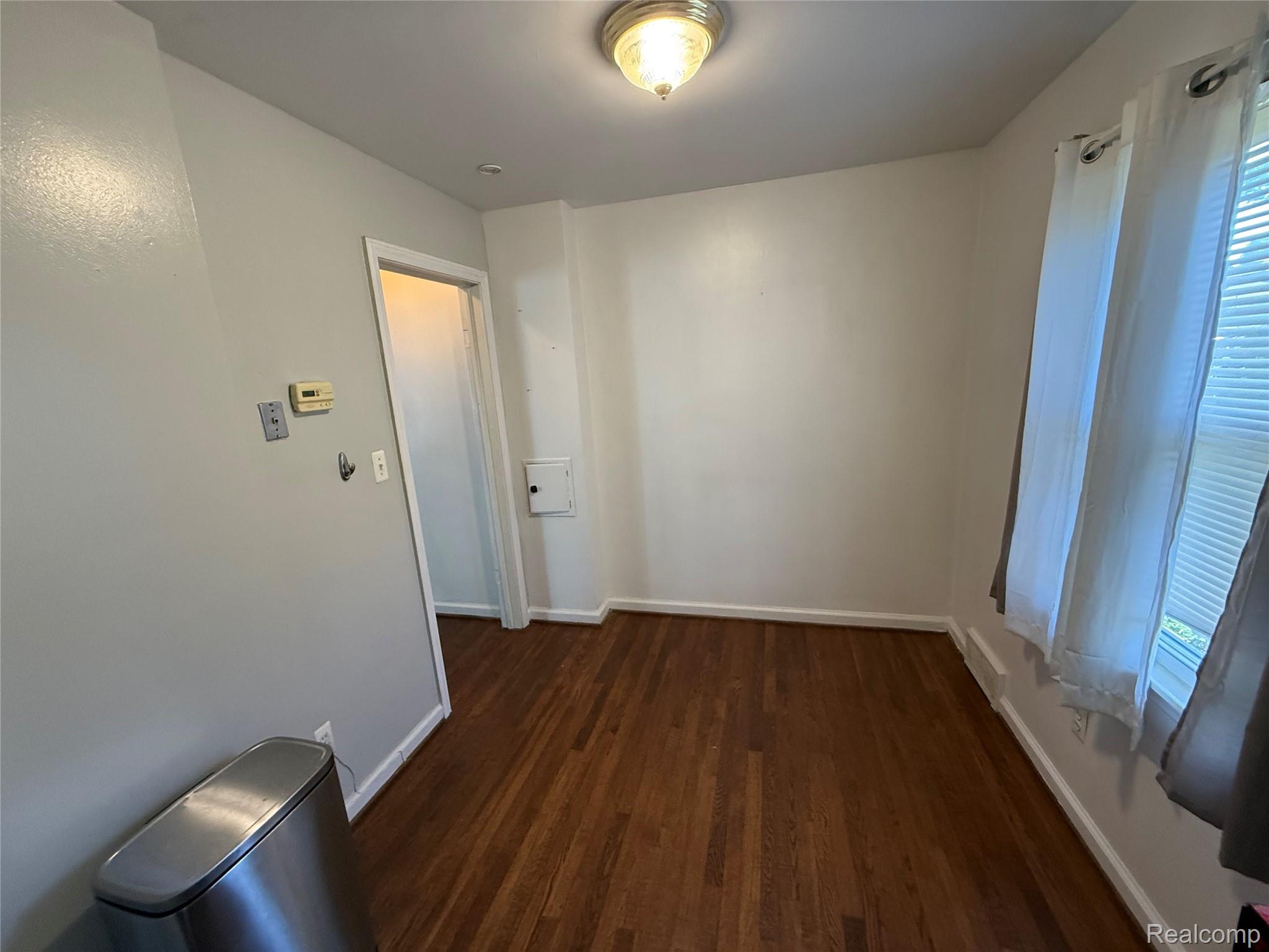 3500 Southfield Road Dearborn, MI 48124 - Photo 6 of 15 Hardwood flooring, painted walls, ceiling-mounted light fixture, window with blinds and curtains, and a built-in electrical panel