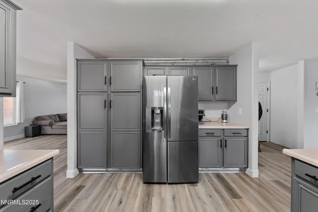 a kitchen with kitchen island wooden floors appliances and cabinets