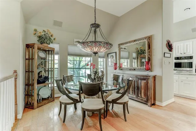 a dining room with furniture a chandelier and wooden floor