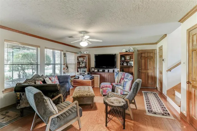 a living room with furniture a flat screen tv and a large window