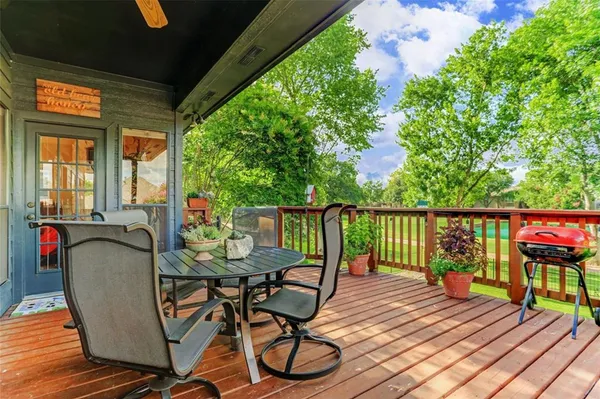a balcony with wooden floor table and chairs