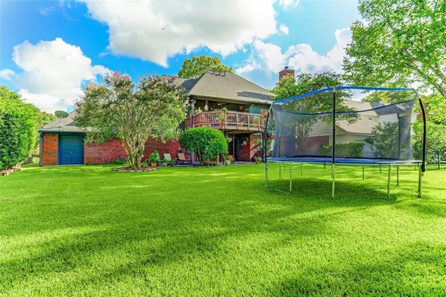 a view of an house with backyard and a tree
