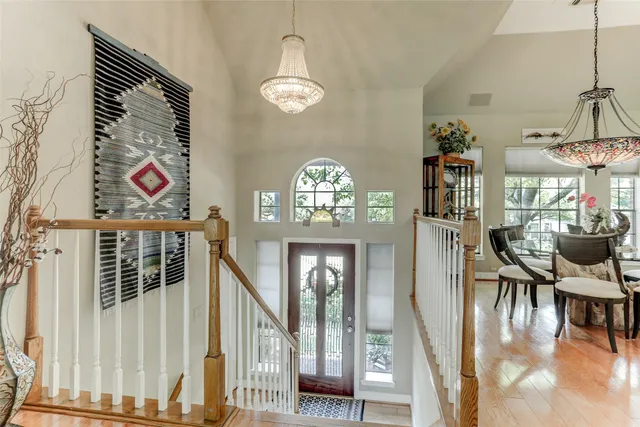 a view of a dining room with furniture a chandelier and wooden floor