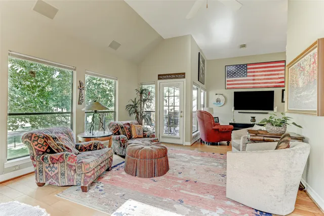 a living room with furniture a flat screen tv and a floor to ceiling window