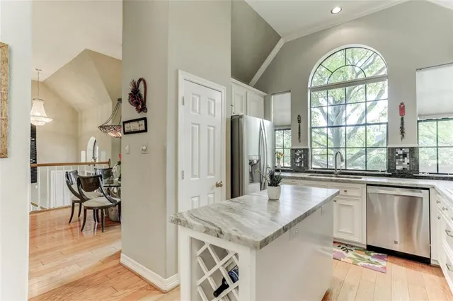 a kitchen with stainless steel appliances granite countertop a window and a refrigerator