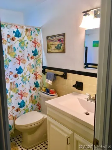 a bathroom with a sink a toilet and curtain