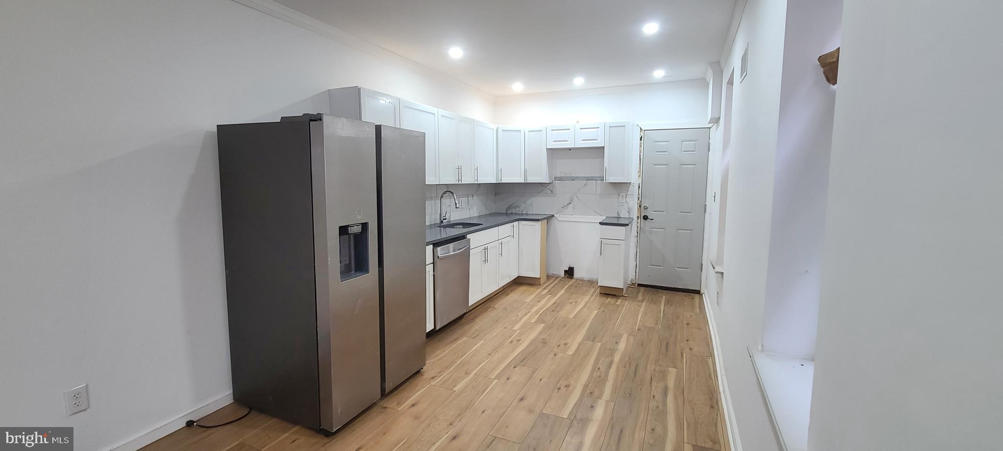 1817 North 26th Street Philadelphia, PA 19121 - Photo 8 of 25 a kitchen with a refrigerator a sink and cabinets
