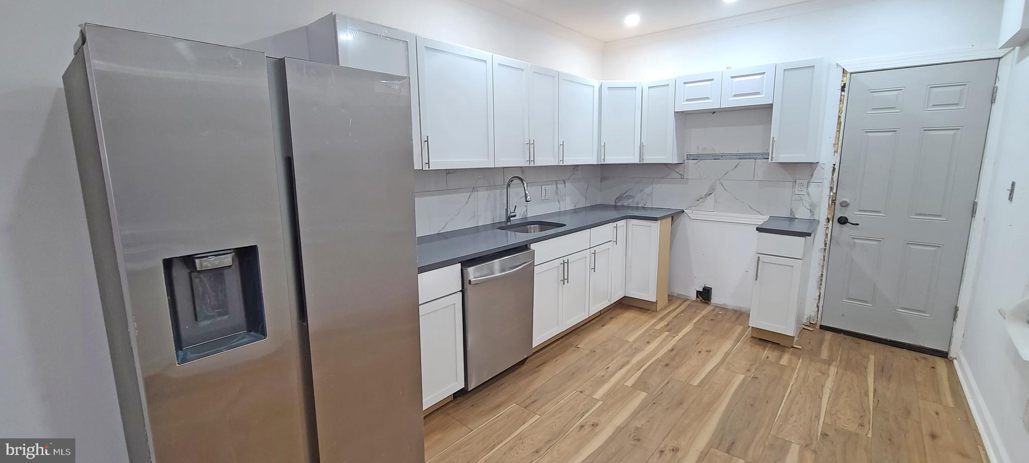 1817 North 26th Street Philadelphia, PA 19121 - Photo 9 of 25 a kitchen with stainless steel appliances a refrigerator sink and white cabinets