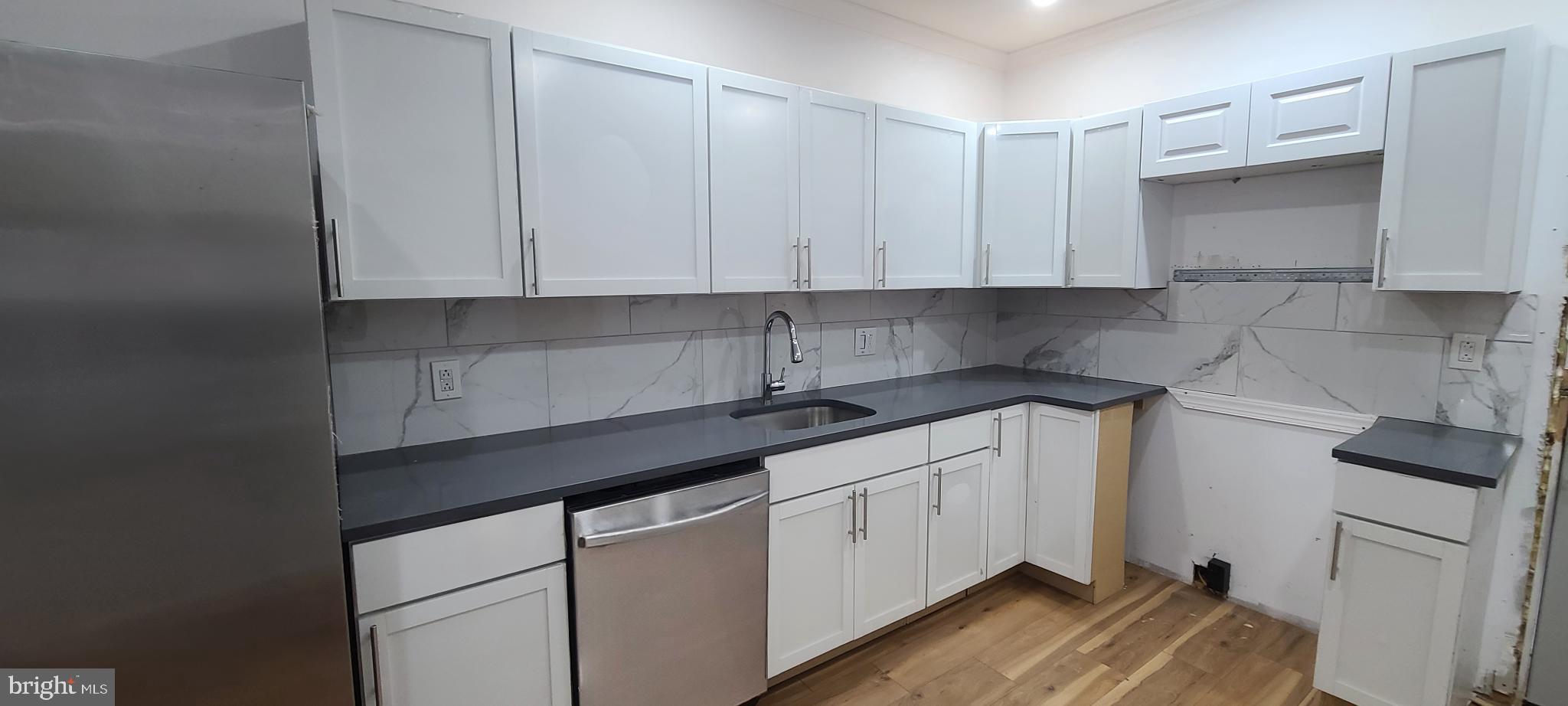 1817 North 26th Street Philadelphia, PA 19121 - Photo 10 of 25 a kitchen with white cabinets and sink