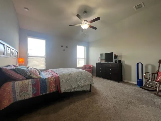 a bedroom with a bed and ceiling fan