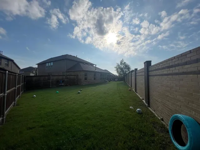 a backyard of a house with lots of green space and plants