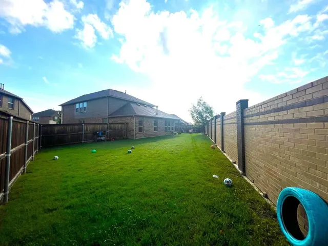 a backyard of a house with lots of green space and plants
