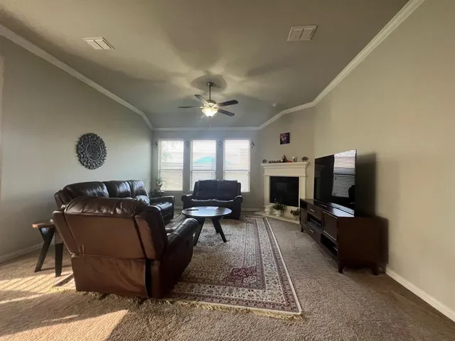 a living room with furniture a fireplace and a flat screen tv