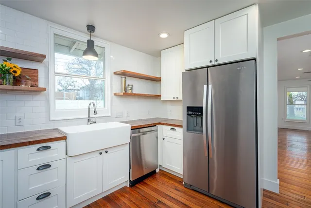 a bathroom with a granite countertop sink a mirror and shower