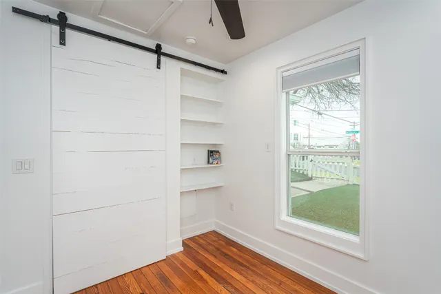 a view of empty room with wooden floor