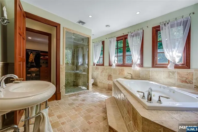 a bathroom with a tub sink and mirror