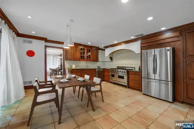 a kitchen with stainless steel appliances granite countertop a refrigerator and a stove top oven