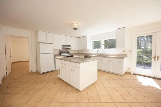 a living room with a large window and chandelier