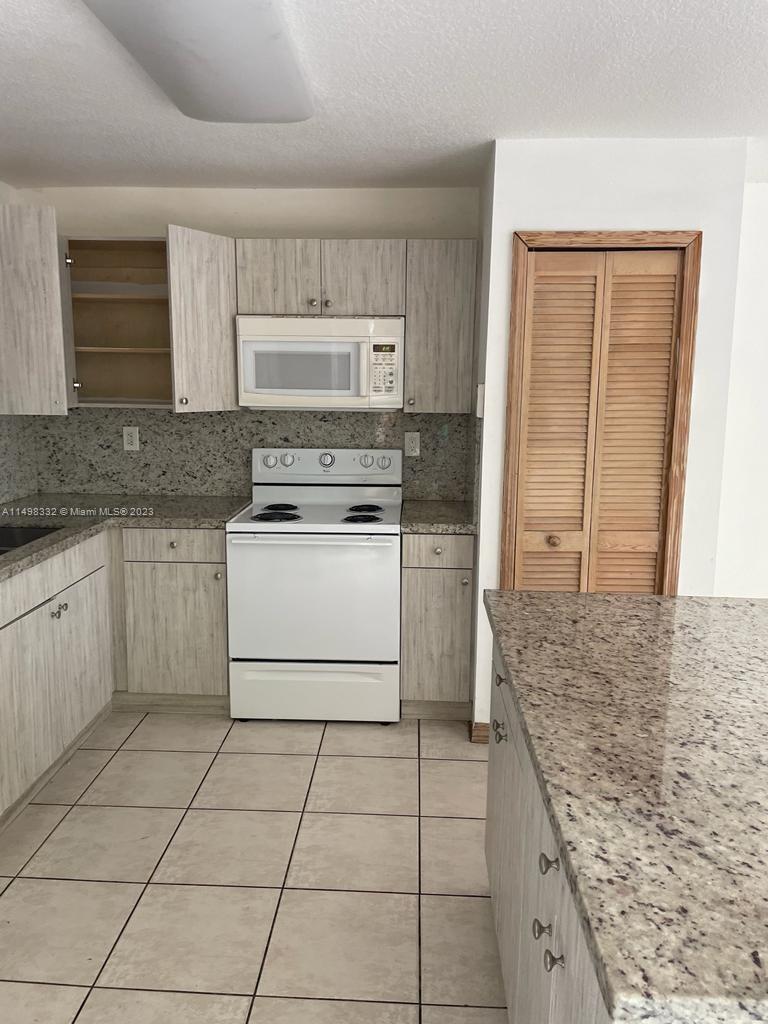 The Hammocks Miami, FL 33196 - Photo 3 of 8 a kitchen with a stove top oven and cabinets