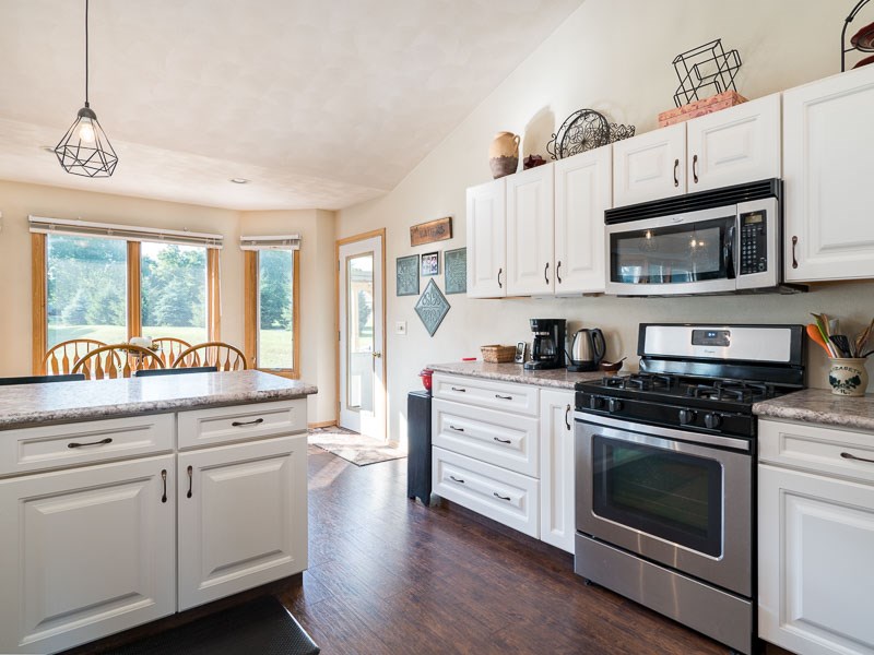 9683 Rambouillet Ridge Roscoe, IL 61073 - Photo 10 of 25 a kitchen with stainless steel appliances granite countertop a stove and white cabinets