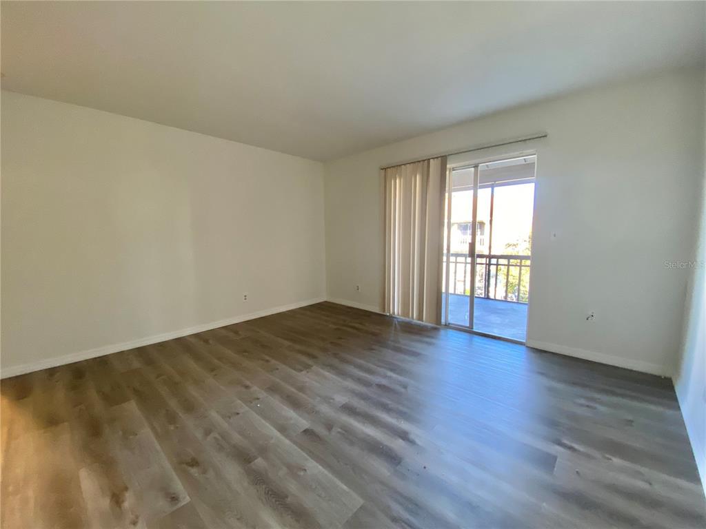 6519 West Newberry Road, Unit 1211 Gainesville, FL 32605 - Photo 3 of 10 a view of an empty room with wooden floor and a window