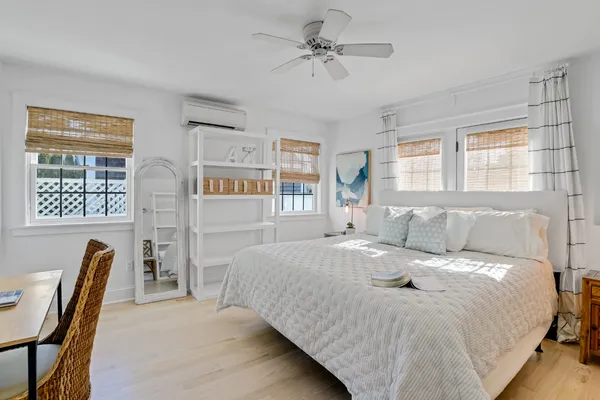 a bedroom with a bed next to a window with a dresser