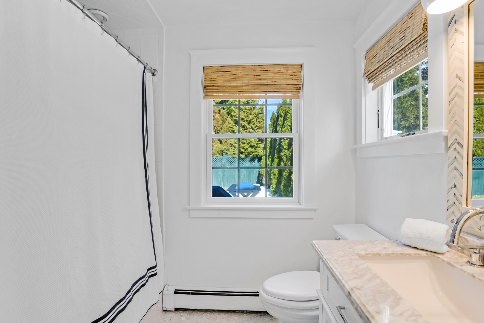 99 Cooke Street Edgartown, MA 02539 - Photo 16 of 26 a bathroom with a granite countertop toilet a sink and a window