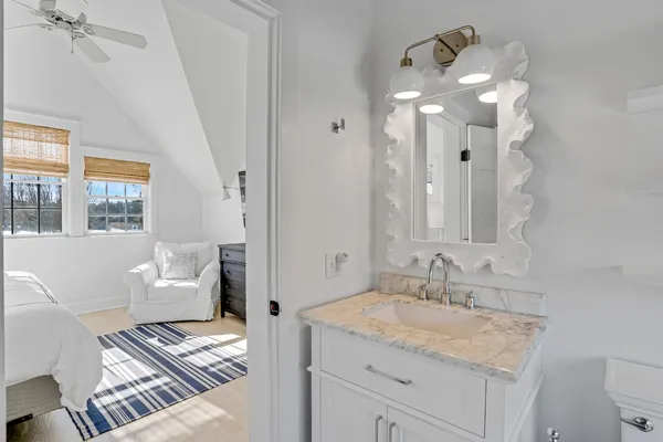 a bathroom with a granite countertop sink a mirror and a shower