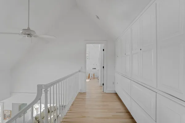 a view of a hallway with wooden floor and staircase