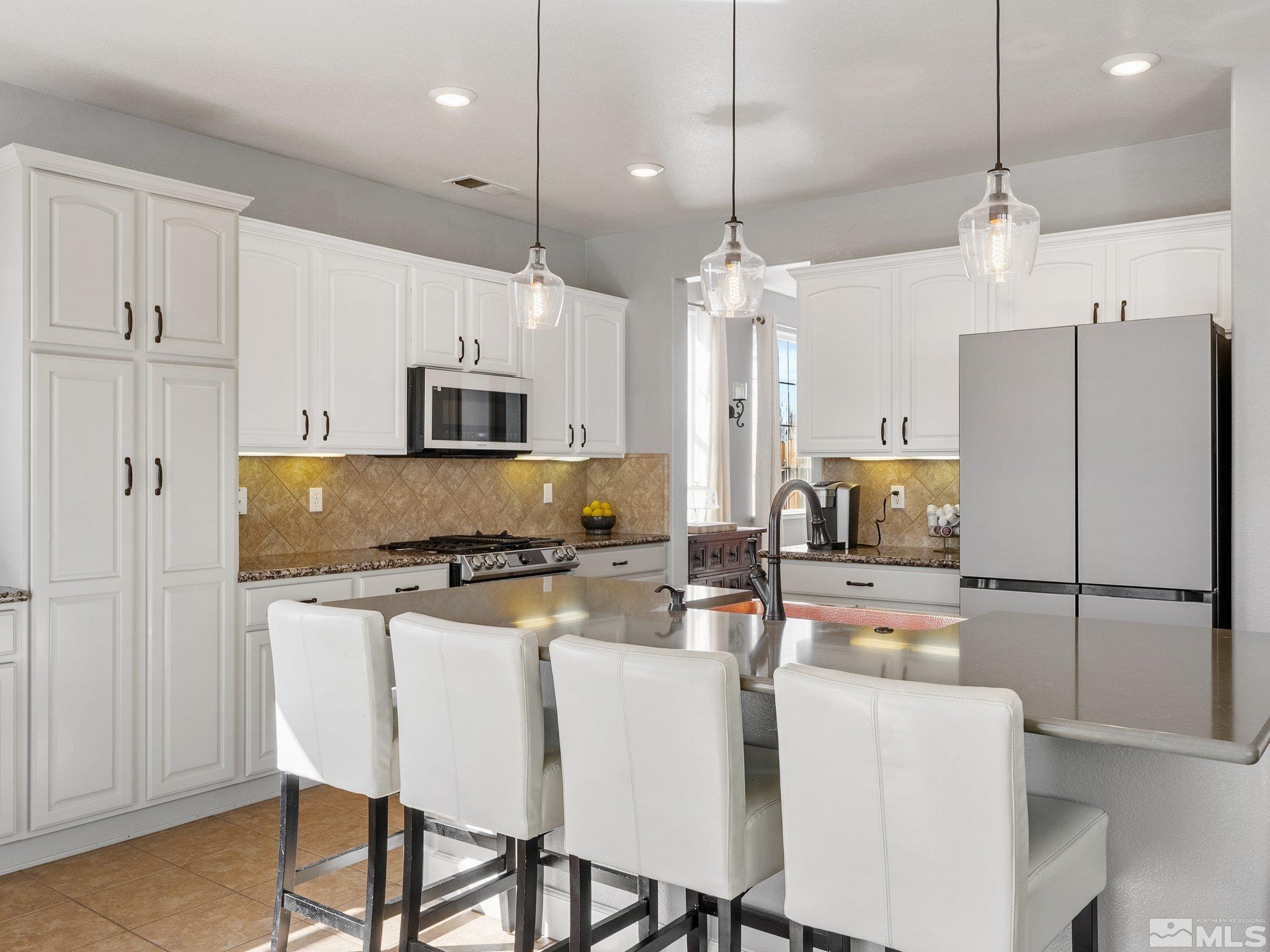 3451 Weaver Place Reno, NV 89512 - Photo 11 of 40 a kitchen with a refrigerator a stove a sink and chairs